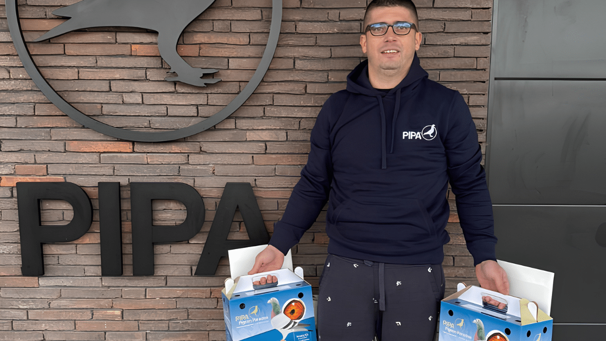 Riciozo Racing Pigeons representative holding pigeon transport boxes at PIPA, celebrating victory in Derby AS Croatia Race 6 over 450 km.
